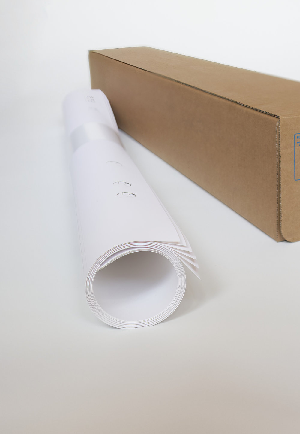 Neben einem Transportkarton aus Pappe liegen zusammengerollte Flipcharts.