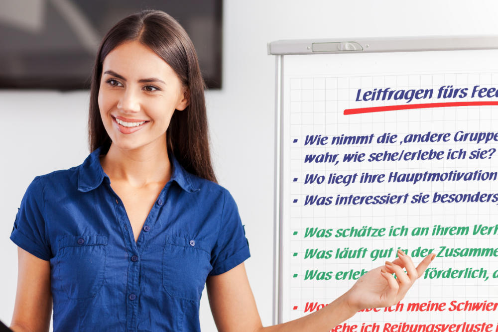 Eine Moderatorin steht neben einem Flipchart-Ständer